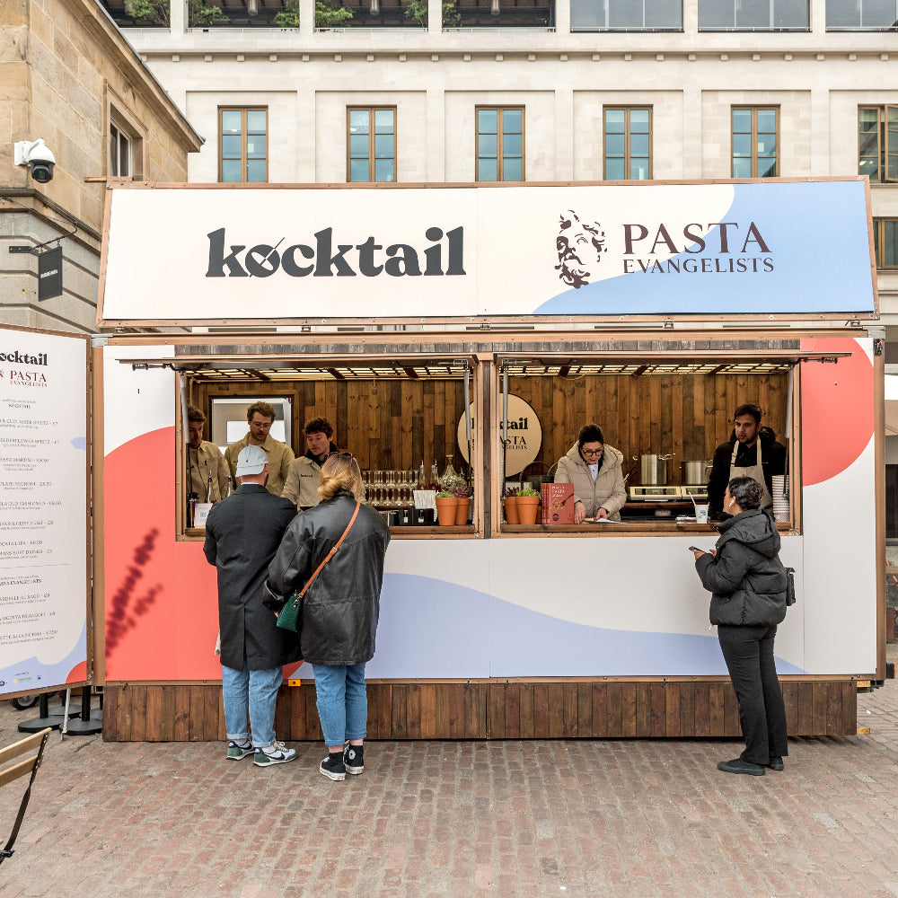 Food truck with 'kocktail' and 'Pasta Evangelists' branding in an urban setting.